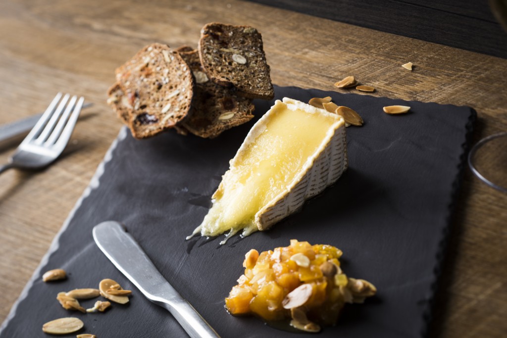 Tranche de fromage Riopelle servie coulante, confit d’abricots secs au citron